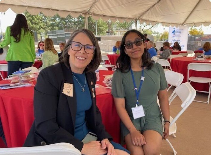 Ariana seated with an Arizona state legislator at an outdoor advocacy event
